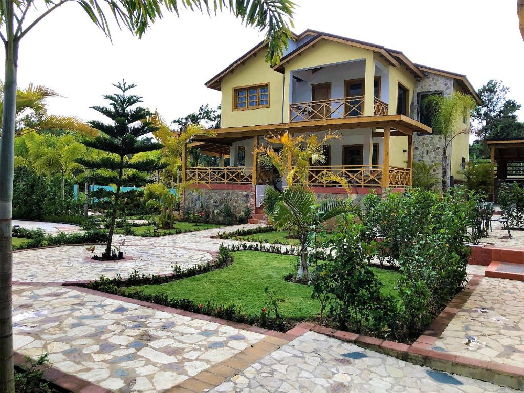 ein Haus mit einem Garten davor in der Unterkunft Villa Yisbel By Hospedify - Villa con Piscina, jacuzzi, mesa de billas, y cancha de Basketball in Jarabacoa