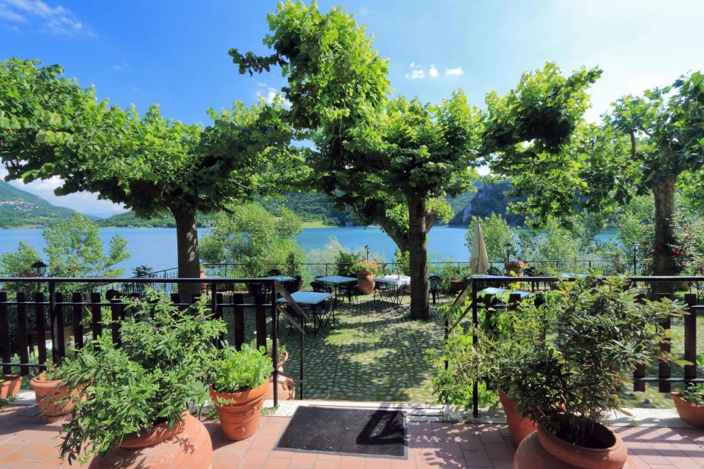 カステル・ディ・トーラにあるHotel Turanoの鉢植えの木が植えられたバルコニーから水辺の景色を望めます。