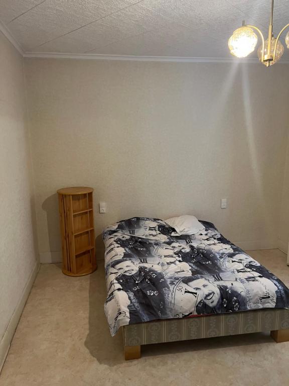 a bedroom with a bed and a night stand at T2 meuble in Oyonnax