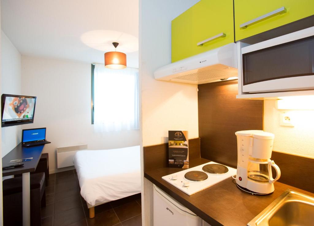 a small room with a kitchen with a blender on a counter at All Suites Appart Hôtel - Bordeaux Lac in Bordeaux