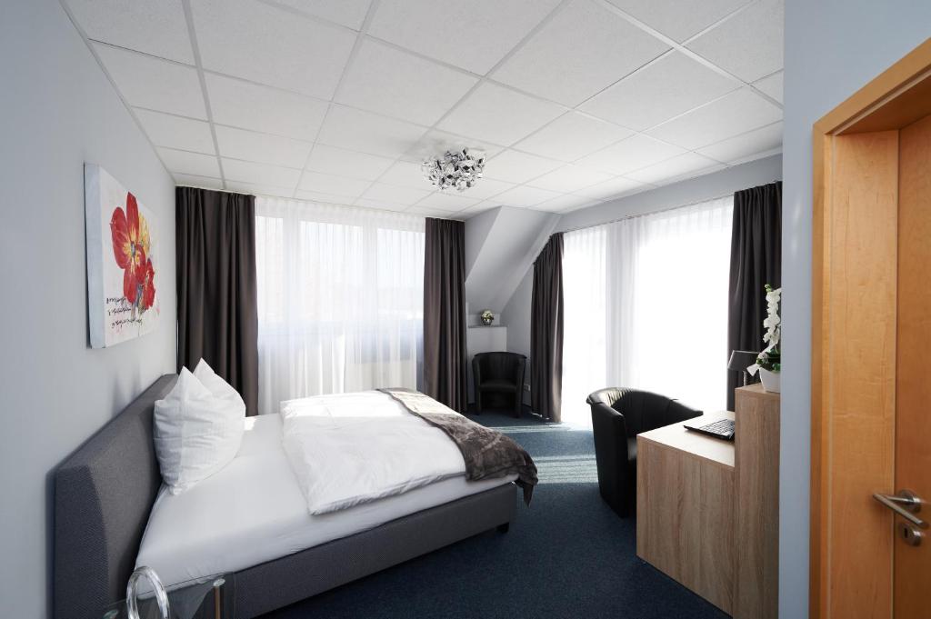 ein Hotelzimmer mit einem Bett und einem Schreibtisch in der Unterkunft Komm' In Hotel in Mechernich