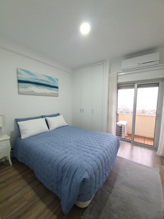 a bedroom with a bed and a large window at Coimbra's Black & White in Coimbra