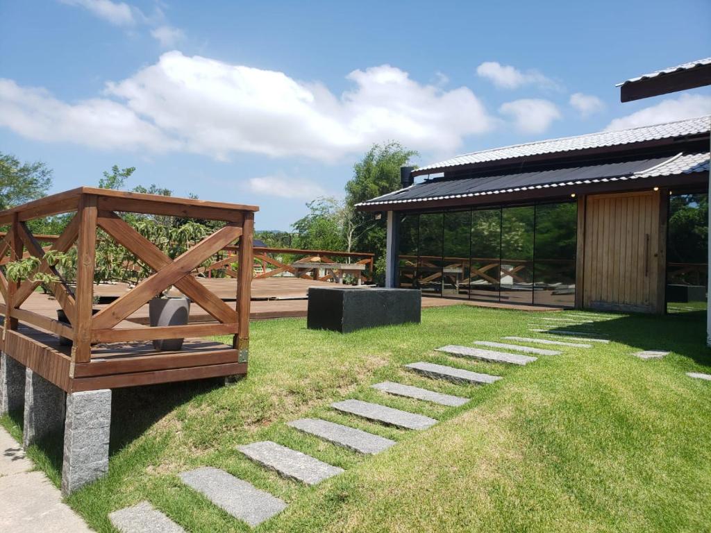 un jardín con un banco de madera y un pabellón en Casa de praia com piscina aquecida área gourmet e jogos, en Florianópolis