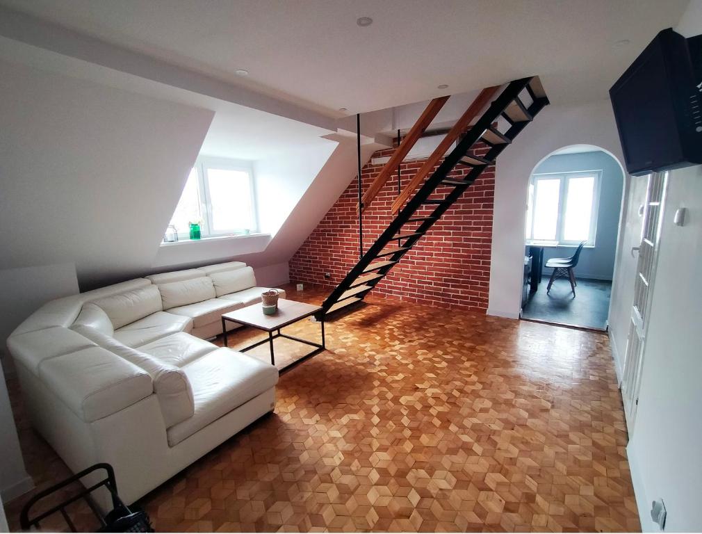 un soggiorno con divano bianco e parete di mattoni di Dwupoziomowy apartament w dzielnicy nadmorskiej BalticRoom1 a Świnoujście