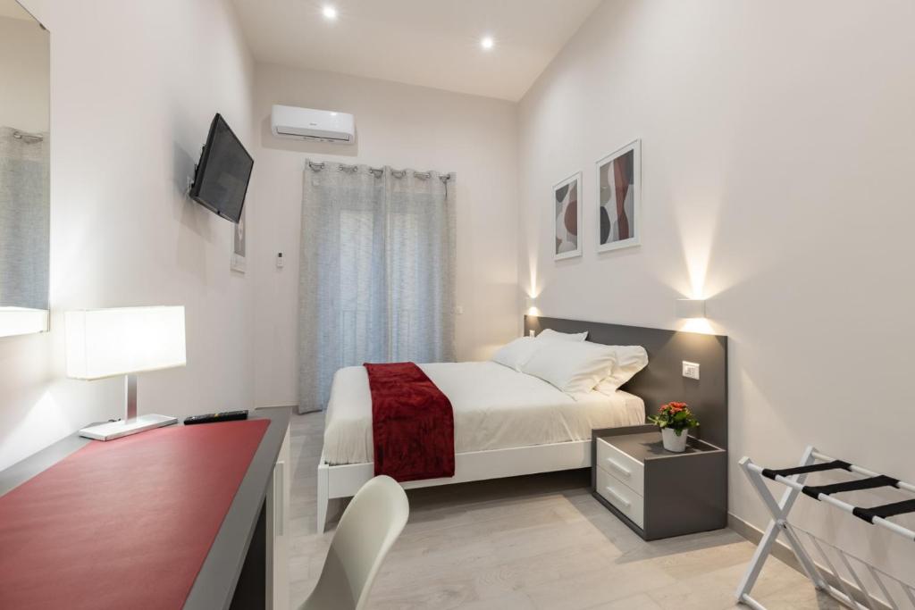- une chambre blanche avec un lit et un bureau dans l'établissement La Torre 31, à Formia