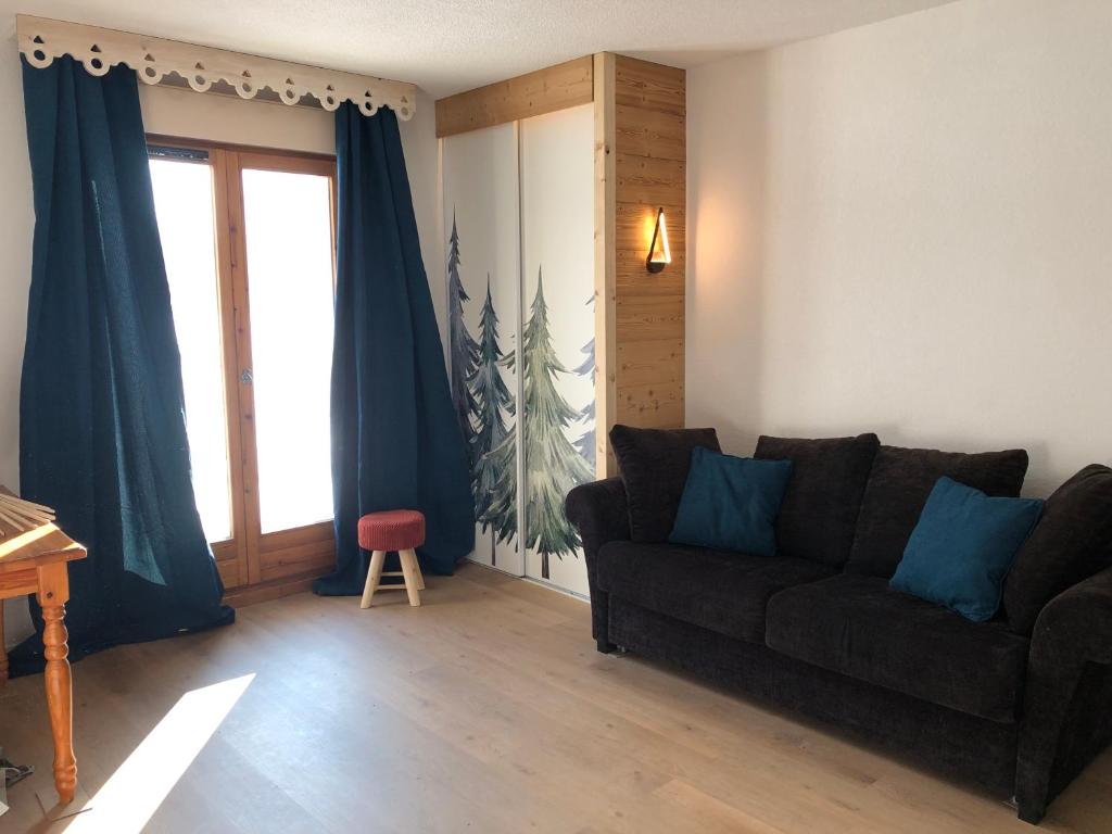 a living room with a couch and a window at Studio - Le D2 du Grand Tetras in Samoëns