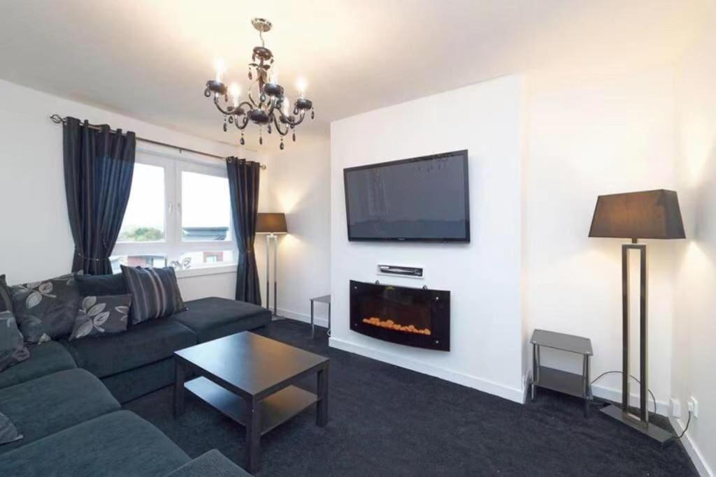 a living room with a couch and a fireplace at Light-luxury Flat in Glasgow