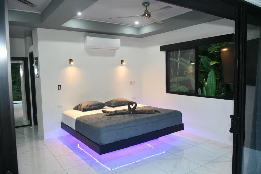 una camera da letto con un letto con luci sul pavimento di Casa Proa a Uvita
