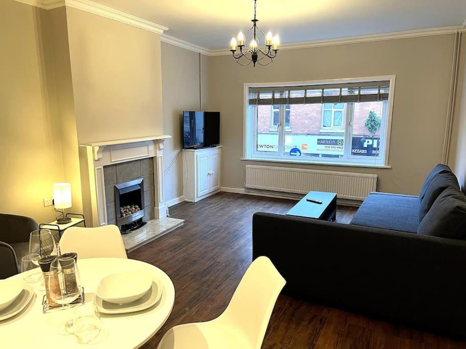 a living room with a couch and a table with chairs at The Ivanhoe Apartment in Rothley