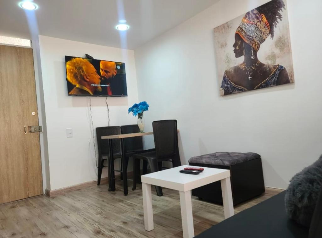 een woonkamer met een tafel en stoelen en een schilderij bij Amoblado Norte en Bogota in Bogota