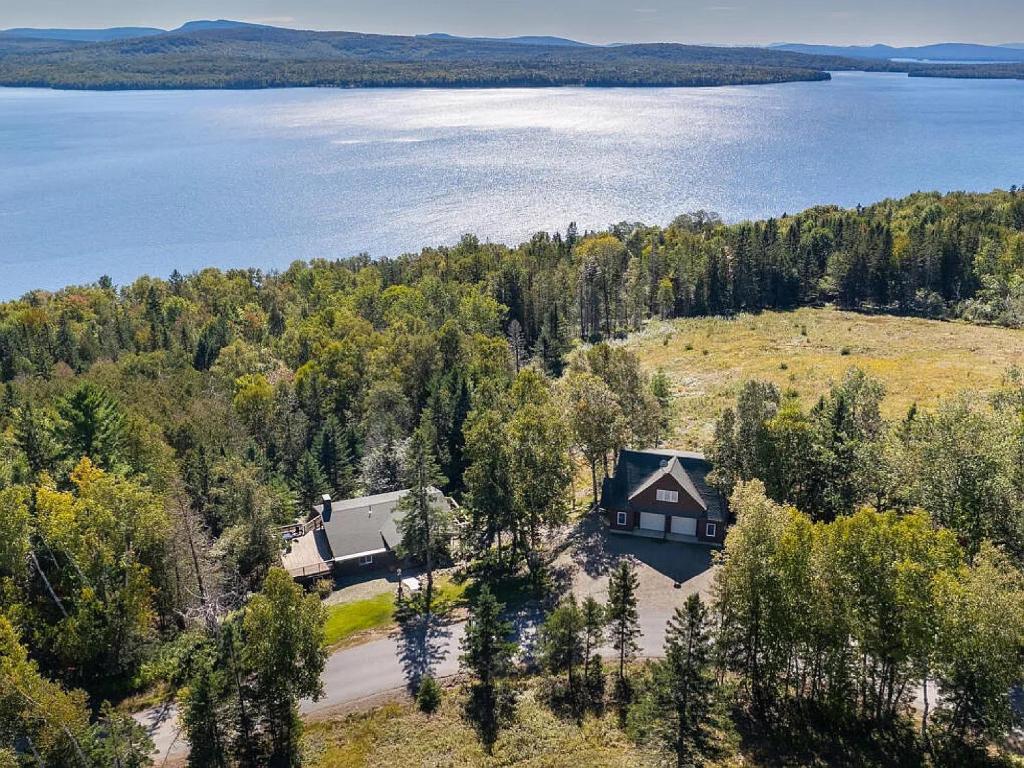 an aerial view of a house on the shore of a lake at Rangeley Lake House, lake access, Saddleback 15min in Rangeley