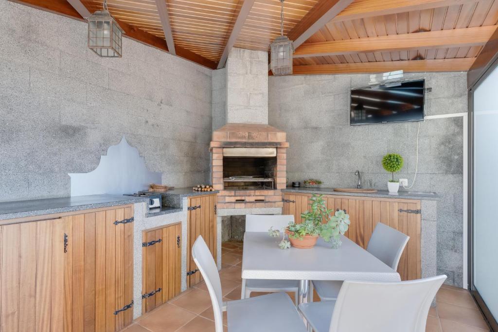 a kitchen with wooden cabinets and a table and chairs at Casa Amarela in Funchal