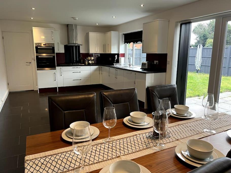 a kitchen with a wooden table with chairs and a dining room at Large 5 Bedroom House Sleeps 10 Ideal for Contractors in Barrow upon Soar