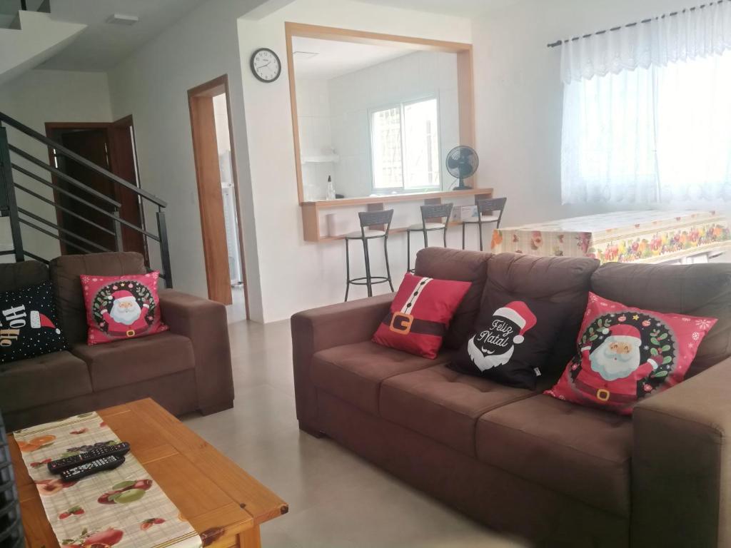 a living room with a brown couch with christmas pillows at Sunny in Florianópolis