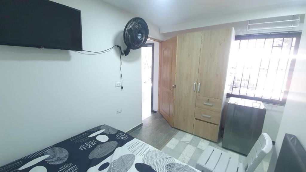 um quarto com uma cama e um relógio na parede em Pequeño apartaestudio em Medellín