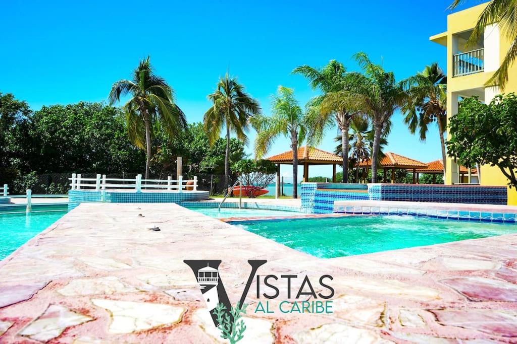 una piscina en un complejo con palmeras en Ocean View, Playas del Caribe en Cabo Rojo