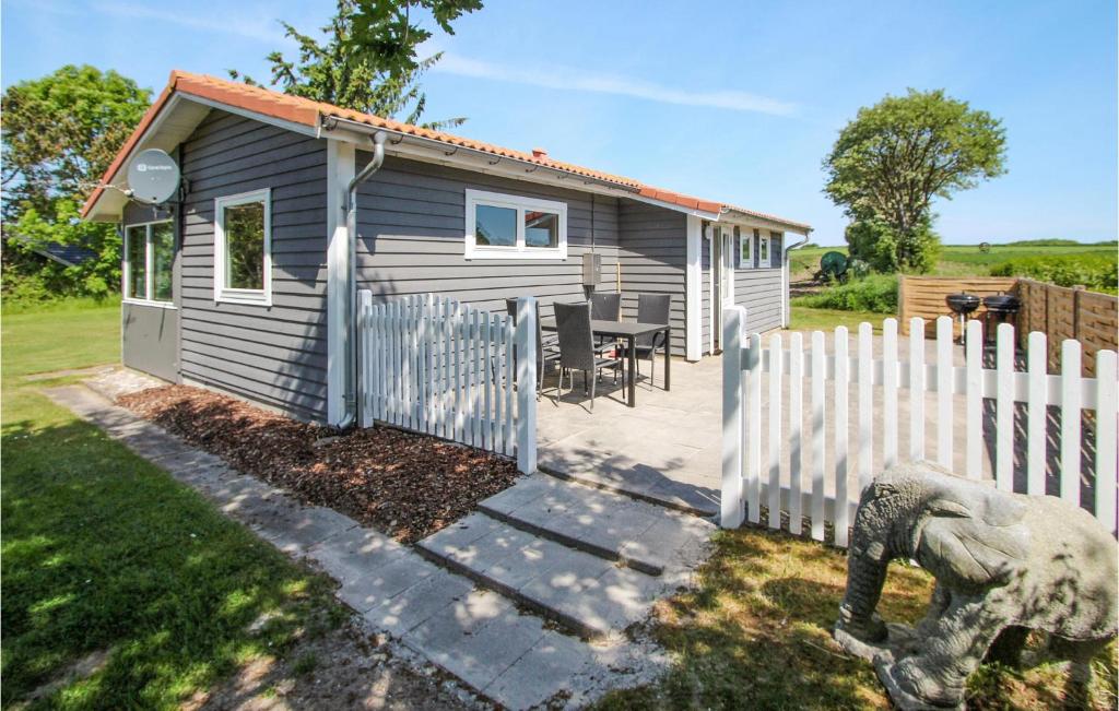 una pequeña casa con una valla al lado de un patio en Gorgeous Home In Sams With Kitchen en Kolby Kås