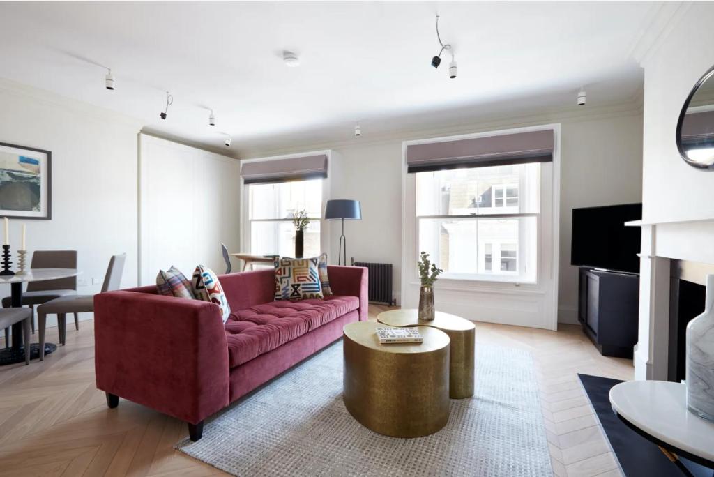 - un salon avec un canapé rouge et une table dans l'établissement Luxurious Covent Garden Penthouse, à Londres