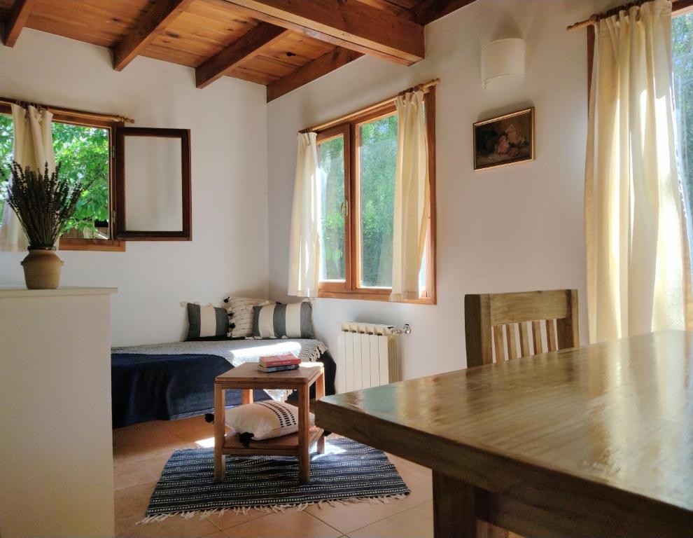 sala de estar con mesa y cama en Cabañas El estribo sur Bariloche 3p en San Carlos de Bariloche