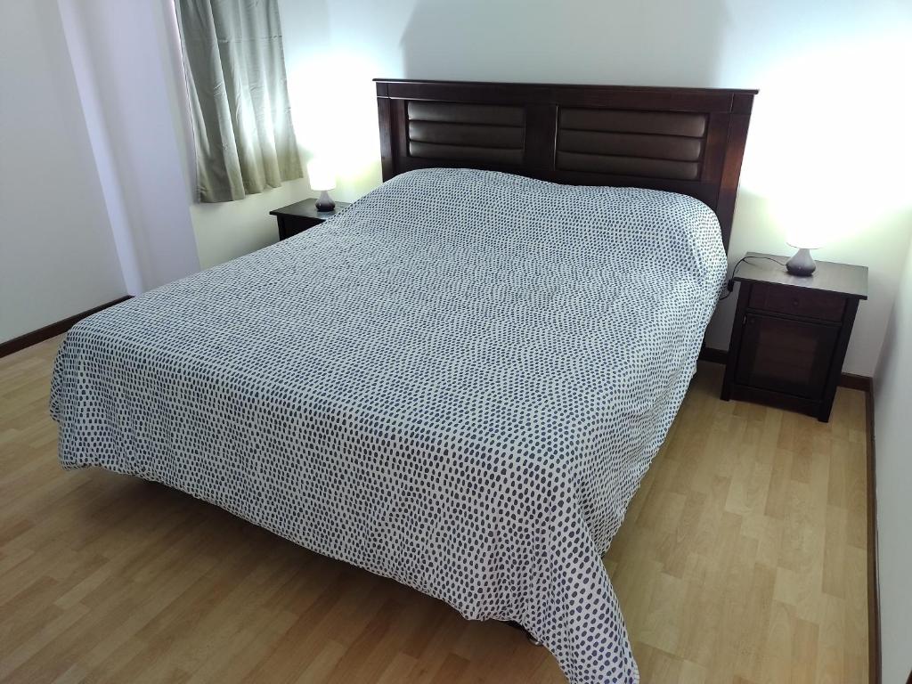 a bedroom with a bed and two night stands at CASA PREMIUM Estadio Carlos Dittborn in Arica