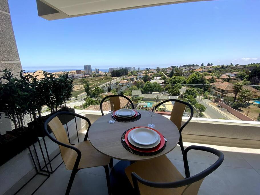 a table and chairs with a view of a city at Departamento Dunas de Concón in Concón