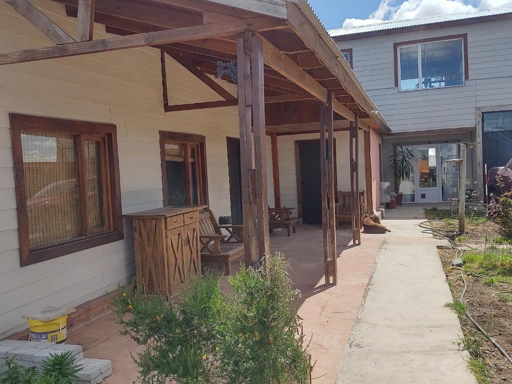 a wooden pergola on the side of a house at FREEDOM Iris in Río Gallegos