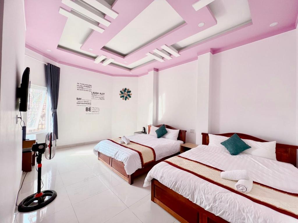 two beds in a room with pink ceilings at Mộc Yên Hotel in Da Lat