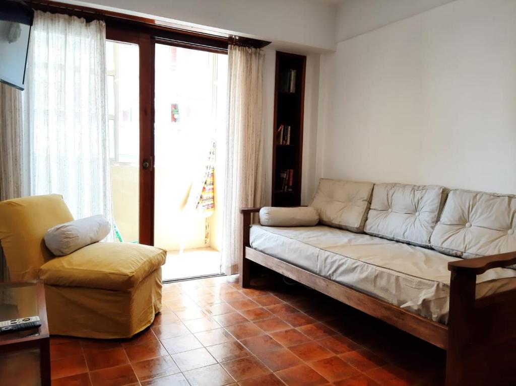 uma sala de estar com um sofá e uma cadeira em Hernandez vista al mar em San Bernardo