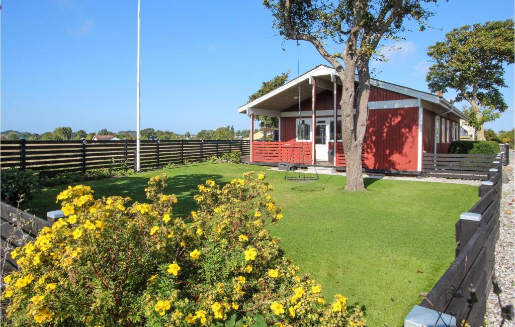 a house with a fence and yellow flowers at Pet Friendly Home In Sams With Kitchen in Ballen