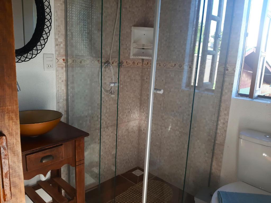 a bathroom with a shower with a sink and a toilet at Cabana Alto do Monte in Gramado