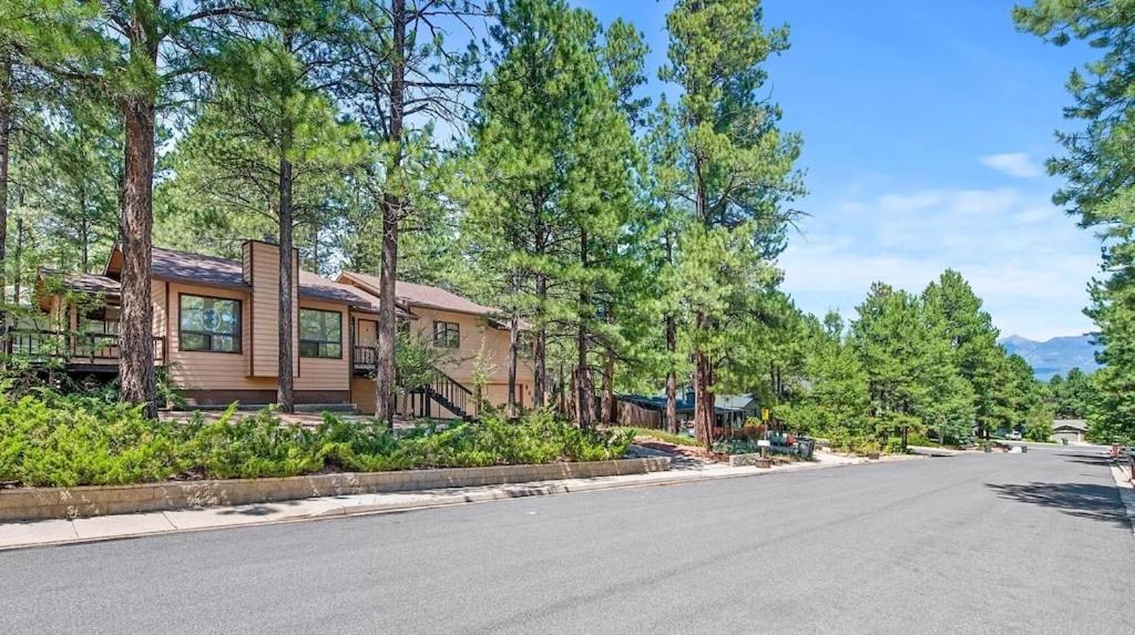 a house on the side of a road at Cheerful Kathys Cabin, King Bed, Hot Tub, Close to NAU, Airport & Hiking Trails! in Flagstaff