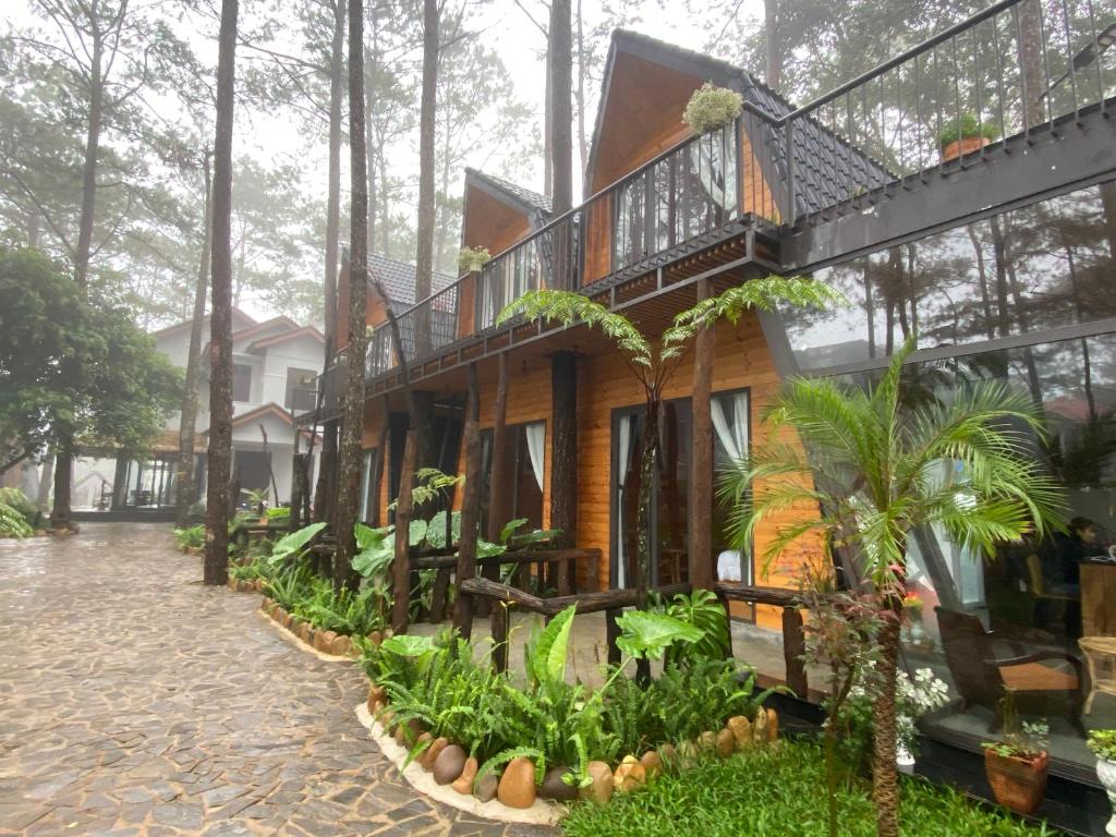 uma casa na floresta com uma varanda em T'MĂNG ĐEENG HOMESTAY em Kon Von Kla