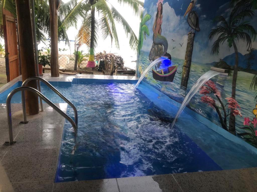 a swimming pool with water fountains in a resort at Cabaña El Paraíso Uveros in San Juan de Urabá