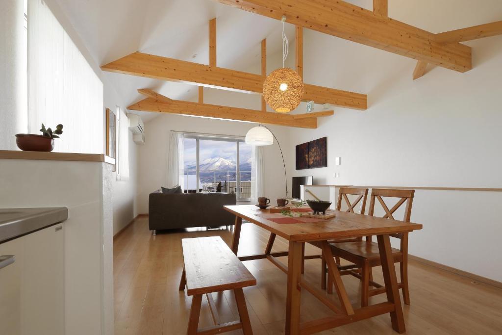 a kitchen and dining room with a table and chairs at Wonderland Furano Pine in Furano