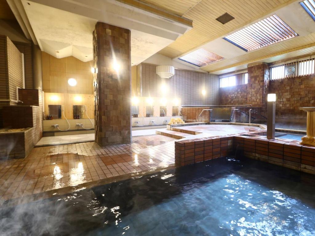 - une grande salle de bains avec une grande piscine d'eau dans l'établissement Hotel Yudanaka, à Yamanouchi