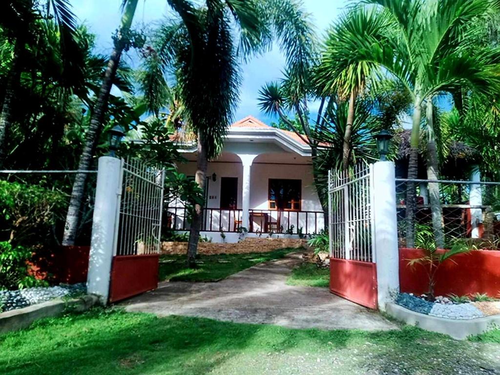 a house with a gate and palm trees at Private 1-BR Bungalow in Moalboal in Moalboal