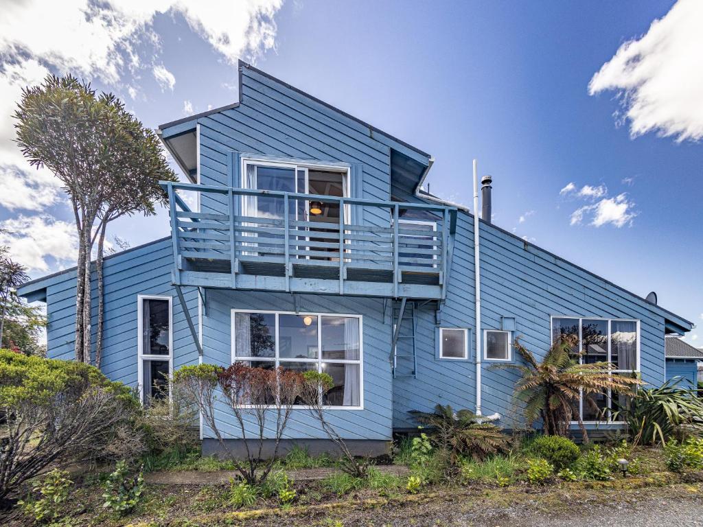 a blue house with a balcony on top of it at Ariki - National Park Holiday Home in National Park