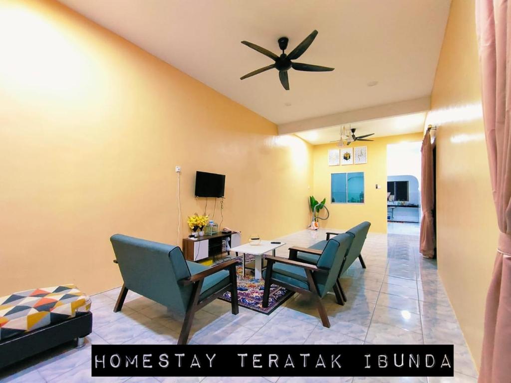 - un salon avec une table, des chaises et un ventilateur de plafond dans l'établissement Homestay Teratak Ibunda, à Jerantut