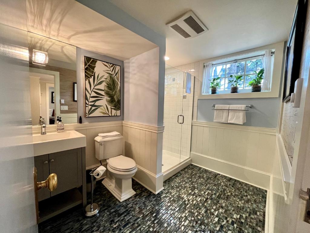 a bathroom with a toilet and a sink and a window at Dougan Suites in Portland