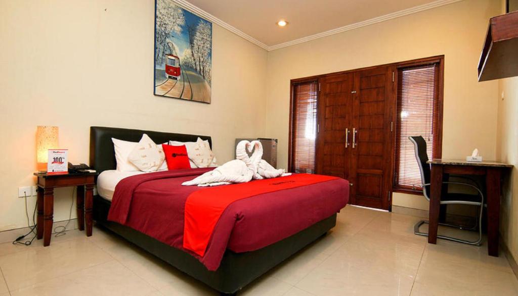 - une chambre avec un lit avec deux animaux rembourrés dans l'établissement Kuta Paradise 777, à Legian