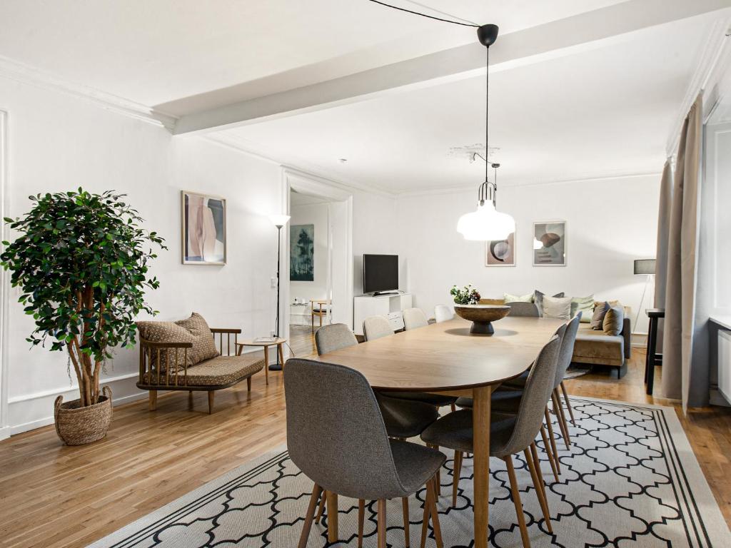 Sanders Stage - Enchanting Four-Bedroom Apartment Near Nyhavn في كوبنهاغن: غرفة طعام وغرفة معيشة مع طاولة وكراسي