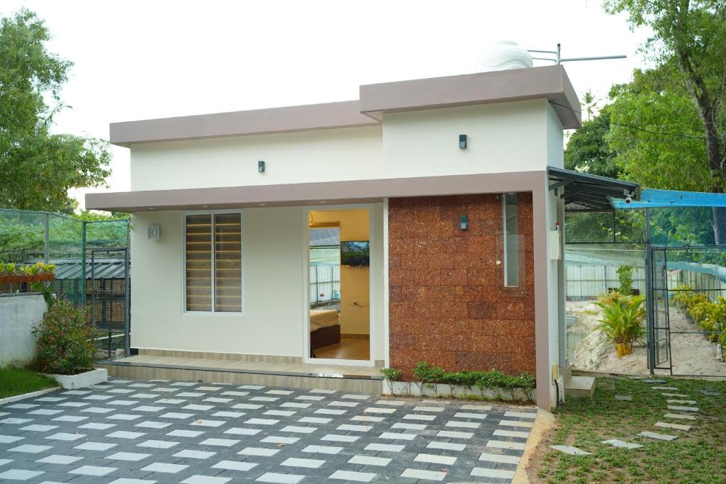 mały biały dom z cegłą w obiekcie MARARI FARM HERITAGE INN w mieście Mararikulam