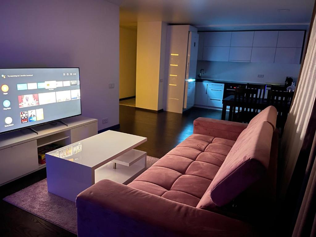 a living room with a couch and a flat screen tv at Very welcome apartment in Panevėžys