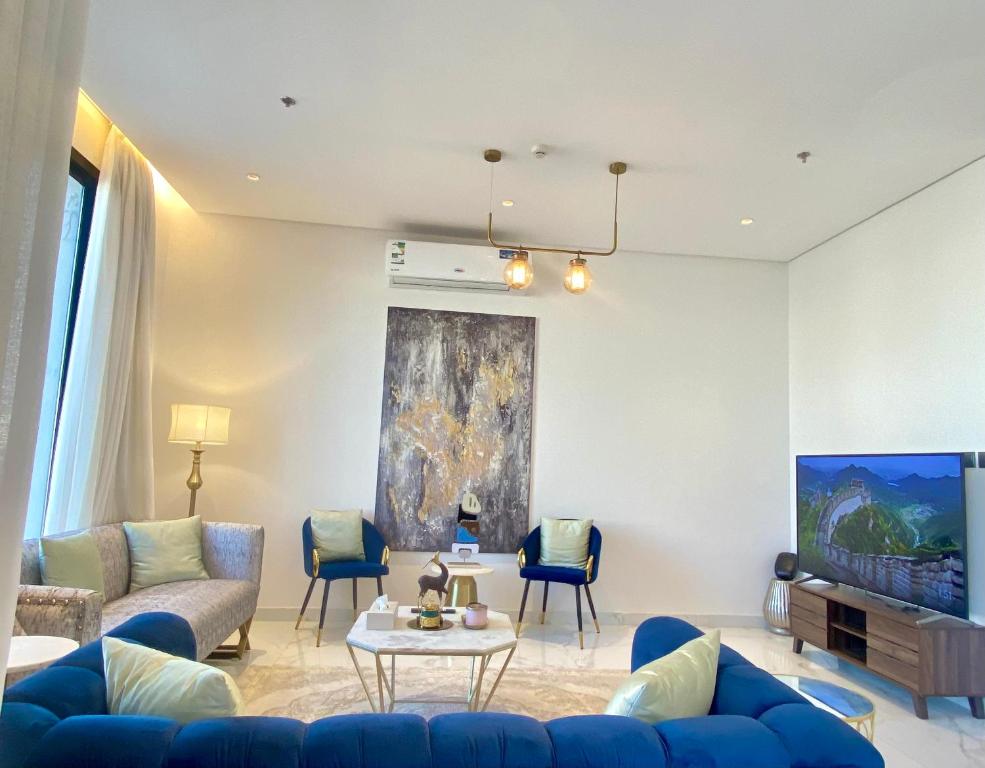 a living room with a blue couch and a tv at Spacious new 2 bedroom Apt-in amazing location B6 in Riyadh