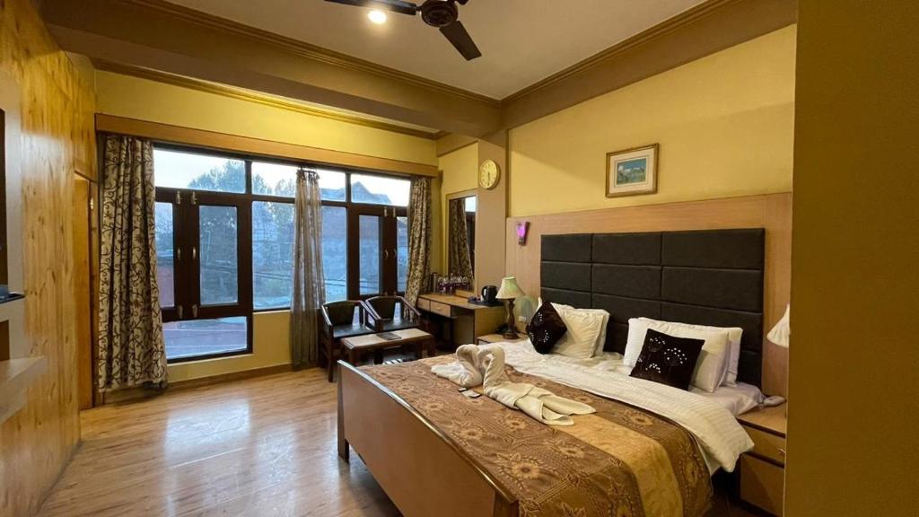 a bedroom with a large bed and a large window at Hotel New Mamta in Srinagar