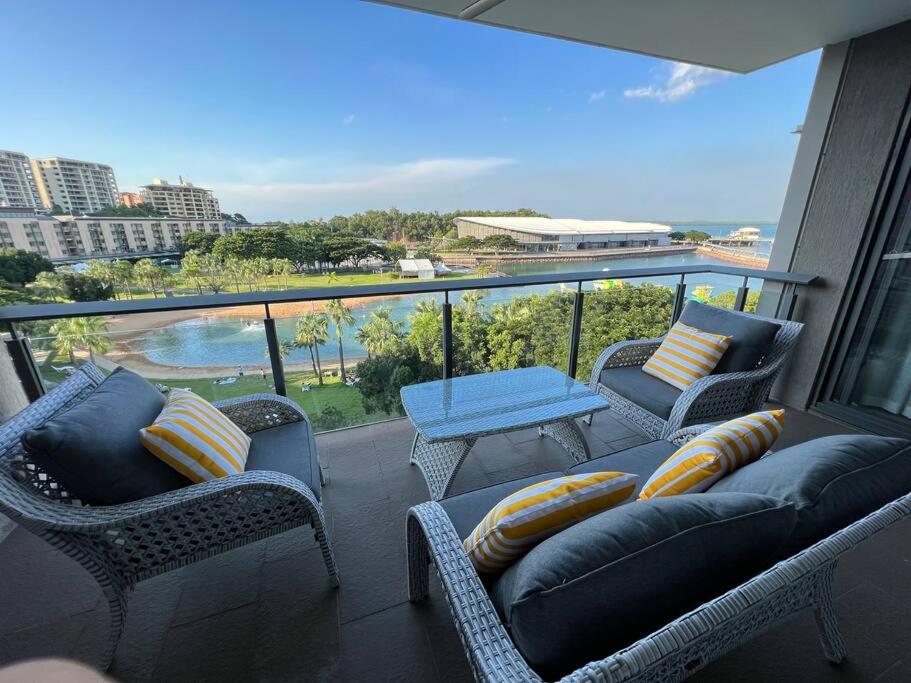 een balkon met stoelen, een bank en een tafel bij Luxury Waterfront Stay 1bdr (breathtaking Views) in Darwin