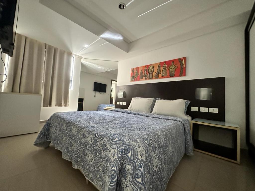 - une chambre avec un grand lit et une couette bleue dans l'établissement FLAT MARINAS PRAIA HOTEL, à João Pessoa