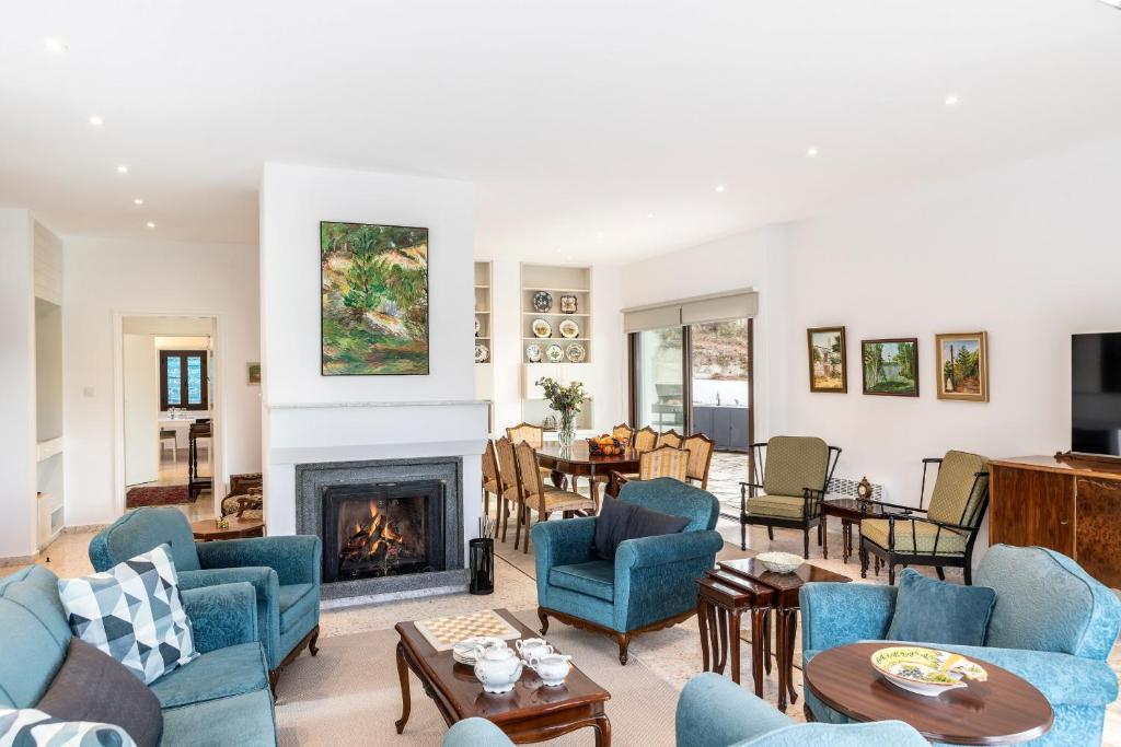 a living room with blue chairs and a fireplace at Platres Forty Pine Trees Cottage in Platres