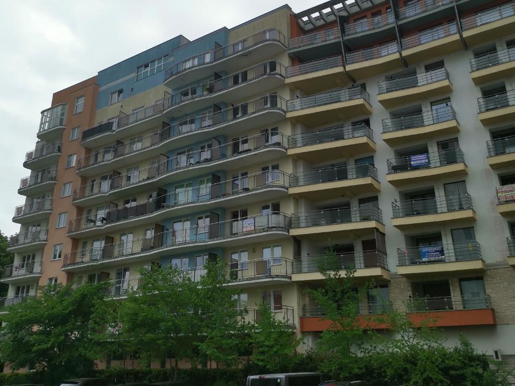 an apartment building with balconies and trees at Apartament Spacerowa z balkonem in Kołobrzeg