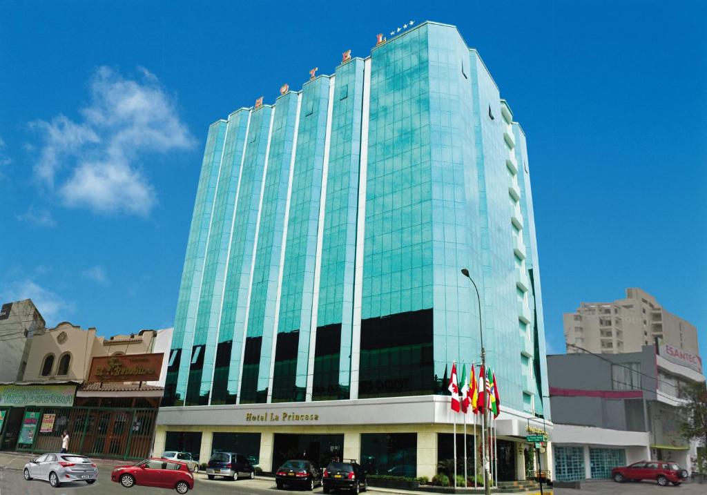 un edificio de cristal alto con coches estacionados frente a él en Hotel Princesa, en Lima